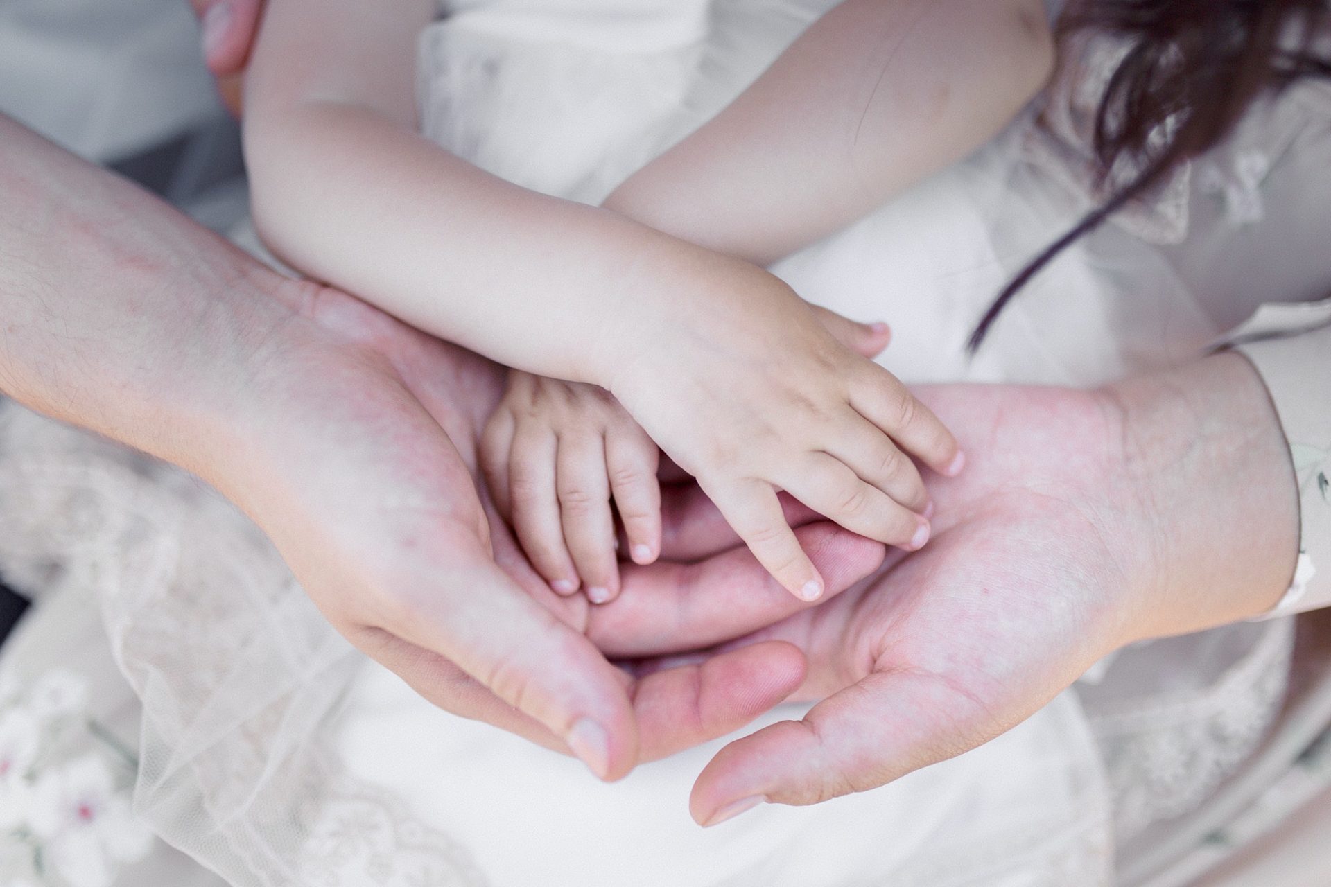 Family holding baby's hands